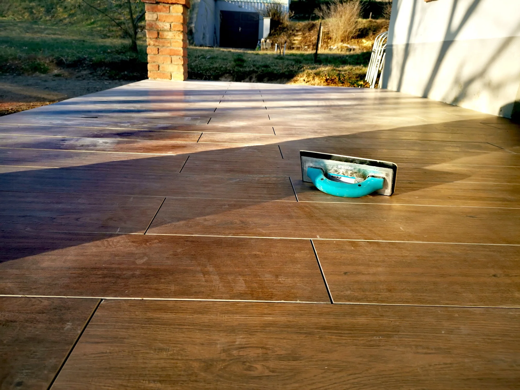 Wood-effect outdoor tiles during installation.