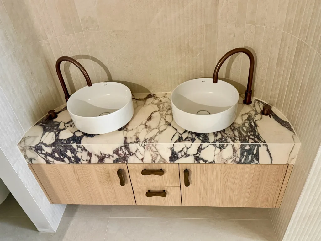Two basins and a marble-effect tiled vanity